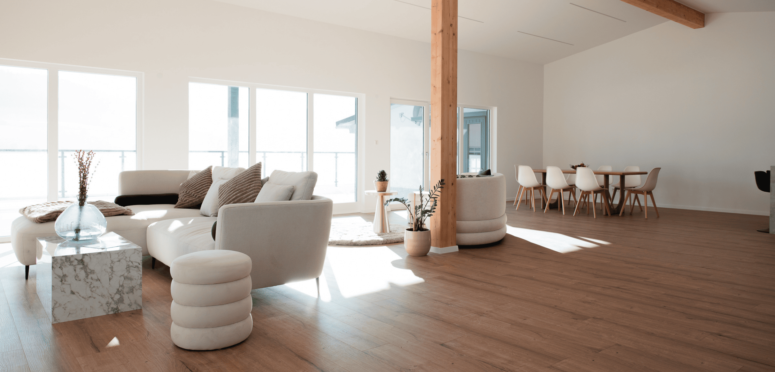 Heller, moderner Wohnbereich im Curl Bites Wellness Loft mit Sofa, Esstisch und Deko – Symbolbild für den Lockenurlaub.